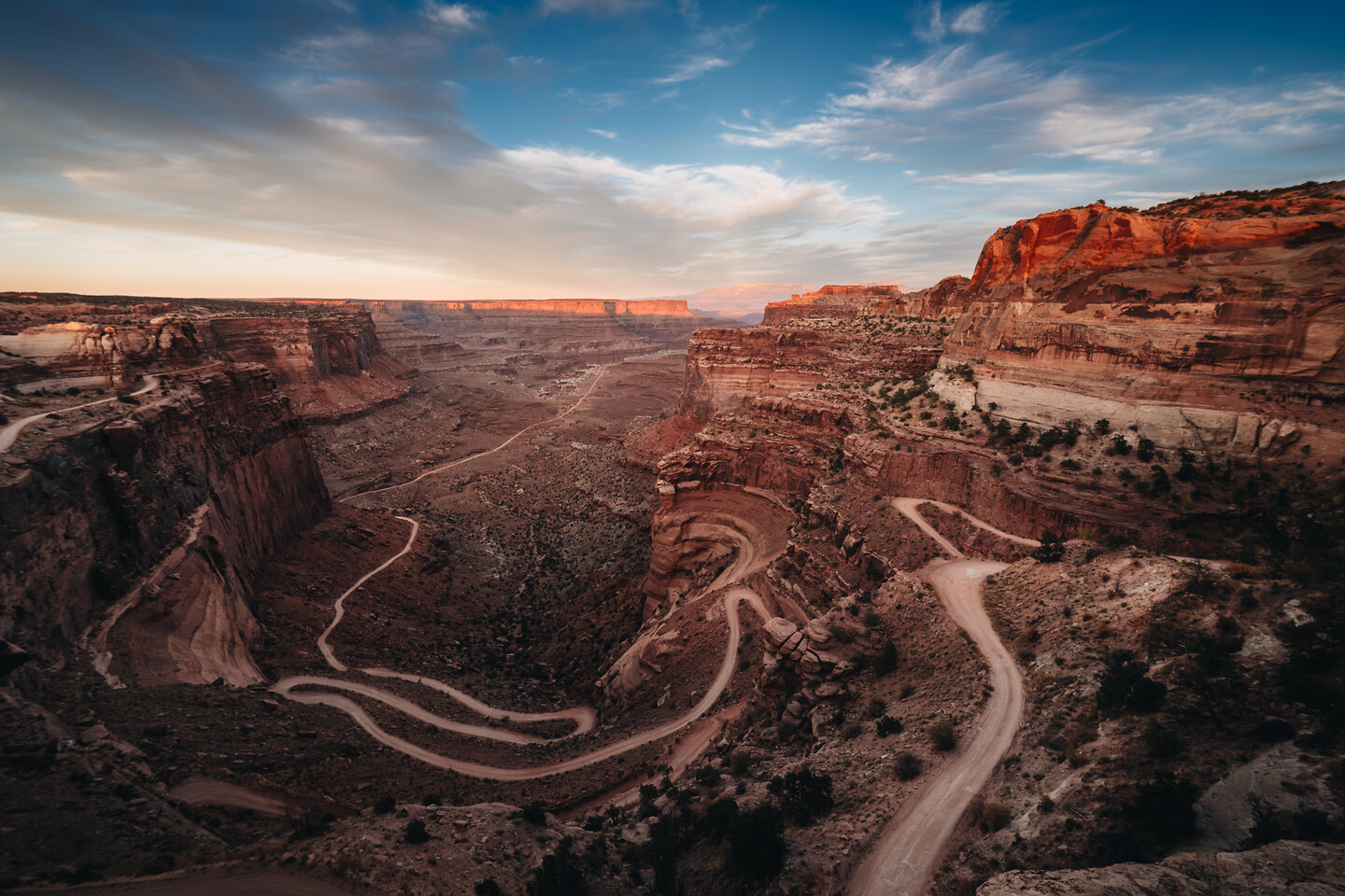 Wide canyon road sweeping into desert distance — licensable editorial frame